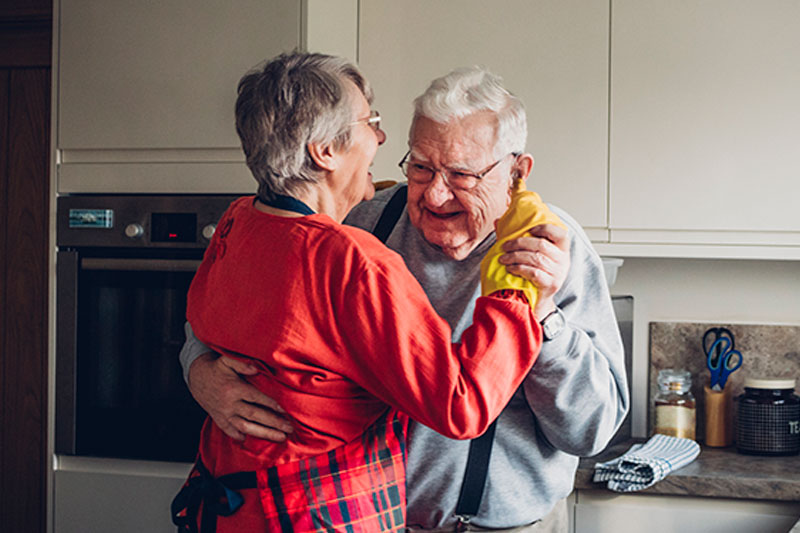 happy-senior-couple-dancing-in-kitchen